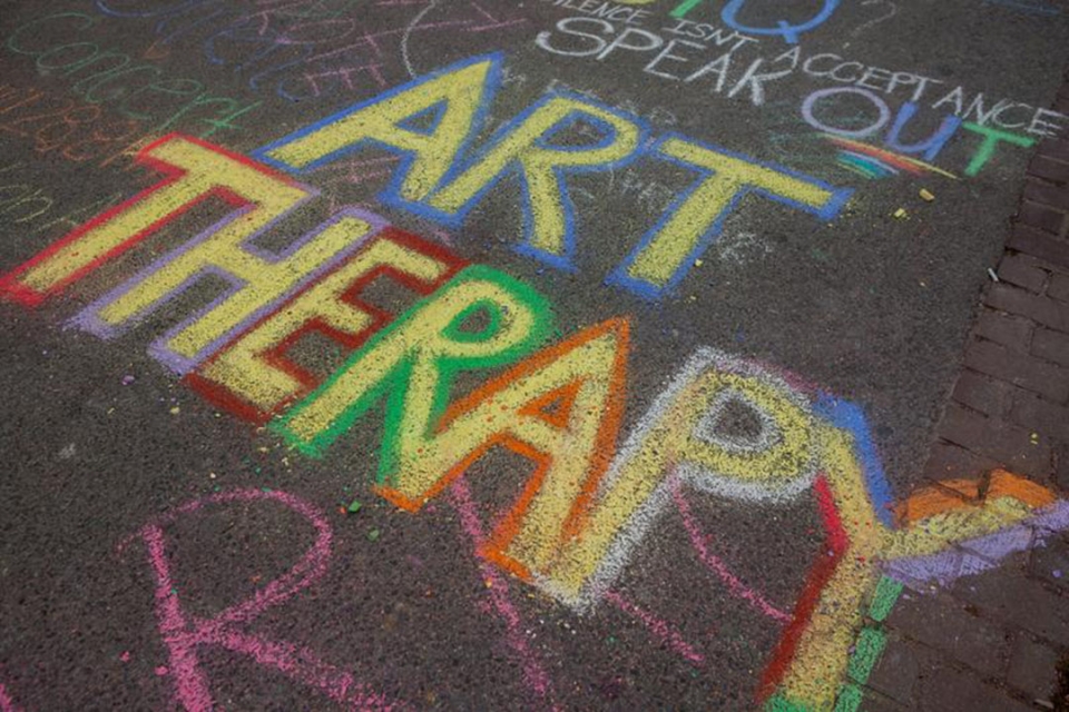 ART THERAPY spelled out in colorful sidewalk chalk