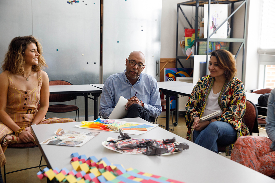 2 female students and a professor at an art therapy classroom