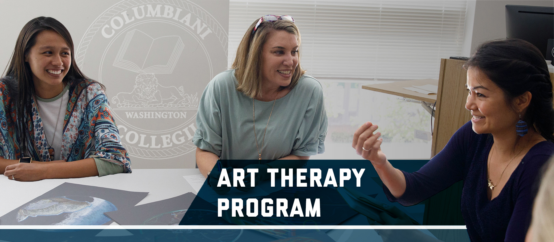 Professor Mary Ellen Ruff talks with two students at a table. Graphic: Art Therapy Program, Columbian College seal