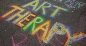 ART THERAPY spelled out in colorful sidewalk chalk