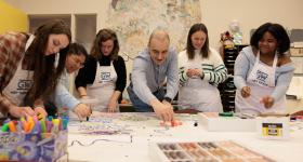 Ulvi Kasimov working on an art project with GW students at a shared table (Photos: William Atkins/GW Today)